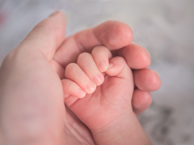 Baby liegt entspannt auf einem weichen rosa Handtuch